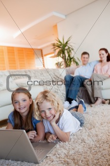Children on the floor using laptop