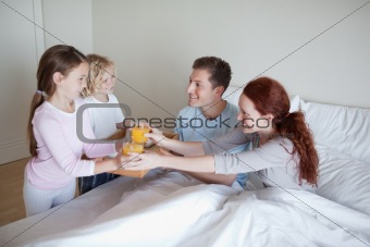 Children surprising their parents with breakfast