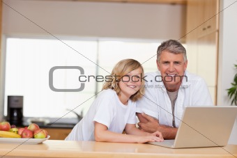 Smiling father and son with laptop