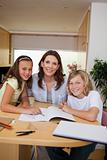 Siblings getting help with homework from mother