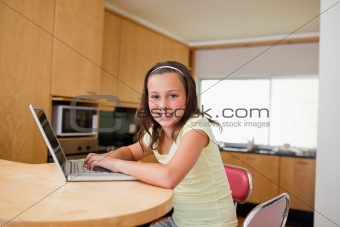 Girl with laptop at the kitchen table