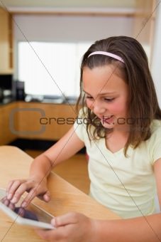 Girl using tablet at the kitchen table