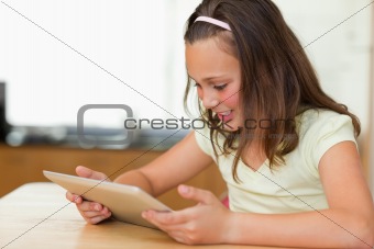 Girl at kitchen table looking at tablet