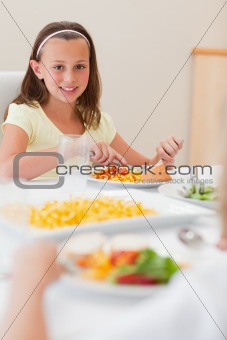 Happy girl having dinner at dinner table