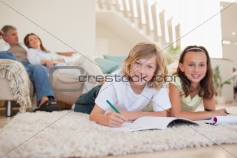 Brother and sister doing homework on the floor