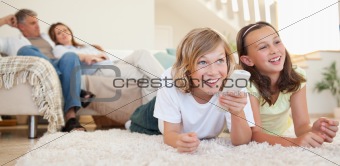 Siblings lying on the floor watching tv