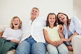 Laughing family sitting on the sofa