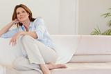 Mature woman in thoughts on sofa
