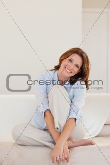 Smiling mature woman sitting on couch