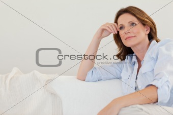 Mature woman in thoughts on couch