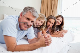 Happy family lying on the bed