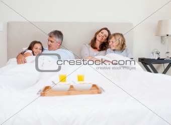 Family about to have breakfast in bed