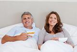Couple eating cereals in bed