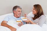 Mature couple having breakfast in bed