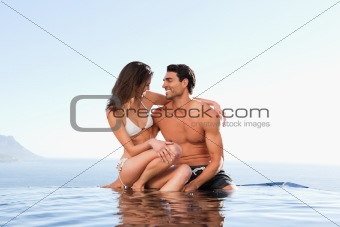 Couple sitting on pool edge together