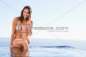 Smiling woman sitting on pool edge