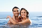 Smiling couple embracing in the pool