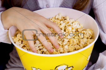 hand in a bucket of popcorn