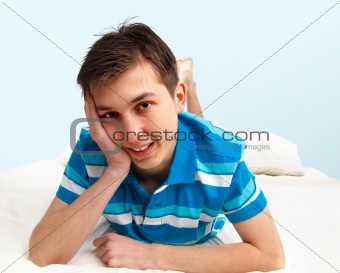 Smiling boy resting on bed
