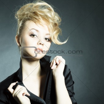 Fashion portrait of beautiful young woman posing on black backgr