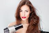 woman with long hair holding blow dryer