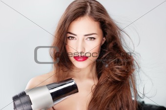 woman with long hair holding blow dryer