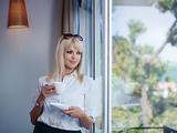 business woman drinking and staring out of window