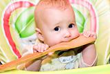 baby biting a wooden spoon