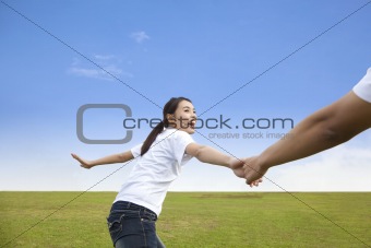 Happy young couple running on the  meadow