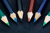 Colorful pencils on dark background lined up