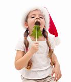 Little girl with a christmas tree shaped candy