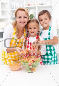 Happy family preparing fresh salad