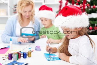 Family making seasonal greeting cards together