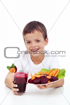 Healthy child with fresh betroot juice and vegetable slices