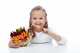 Little girl munching on a carrot stick