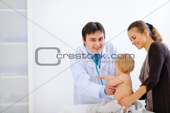 Pediatric doctor examines baby using a stethoscope 
