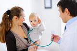 Cute baby on mamas hand playing with stethoscope 
