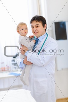 Portrait of happy cute baby on hands of pediatrician
