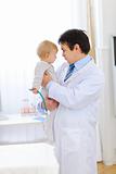 Portrait of pediatric doctor playing with baby 
