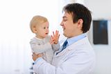 Portrait of pediatrician with baby on hands
