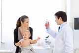 Pediatrician doctor with syringe, tense mother and unhappy baby
