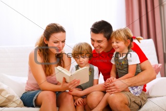 Mother and father reading to twins daughters
