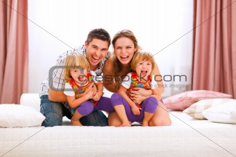 Family portrait of happy mom dad and twins daughters having fun time
