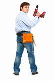 Full length portrait of construction worker with drill look back
