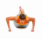 Healthy young man  making push up exercise on fitness ball isolated on white
