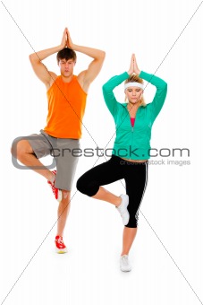 Fitness girl and man in sportswear doing yoga isolated on white
