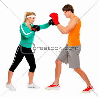 Young woman and man in boxing gloves practicing isolated on white 