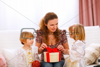 Mother opening gift presented by twins girl
