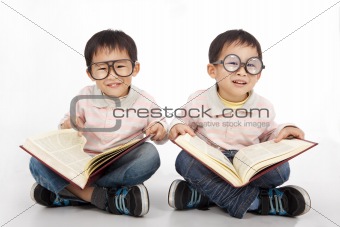 Happy kids with big book wearing black glasses