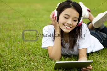 happy girl using tablet pc on the grass
